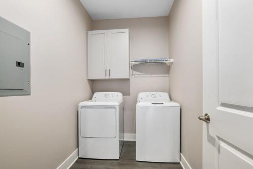 a laundry room with two washing machines and cabinets at Modern 16BR 16BA Condos w Garage and Patio in Wyoming