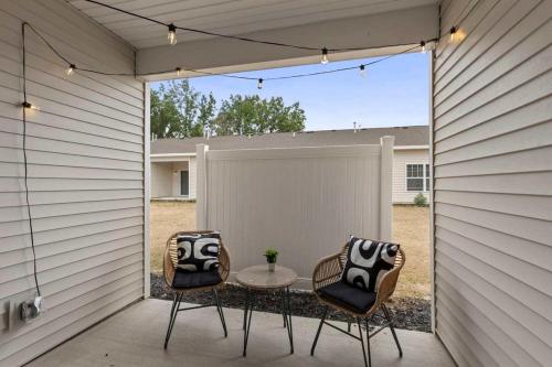 a patio with two chairs and a table and a fence at Modern 16BR 16BA Condos w Garage and Patio in Wyoming