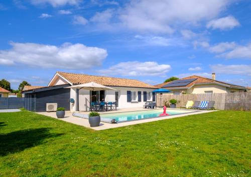 une maison avec une piscine dans une cour dans l'établissement Villa Hélène, à Parentis-en-Born
