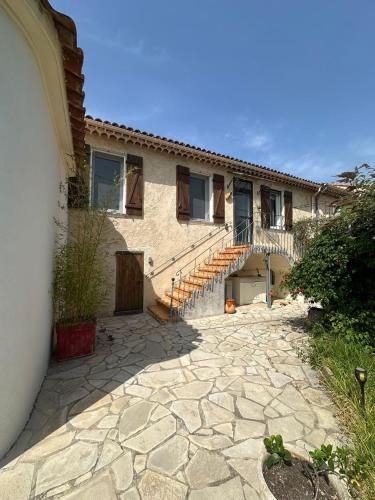 une maison avec une passerelle en pierre à côté d'un bâtiment dans l'établissement Le Mas Piermonde, à Hyères