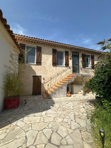une maison avec des escaliers et un patio en pierre dans l'établissement Le Mas Piermonde, à Hyères