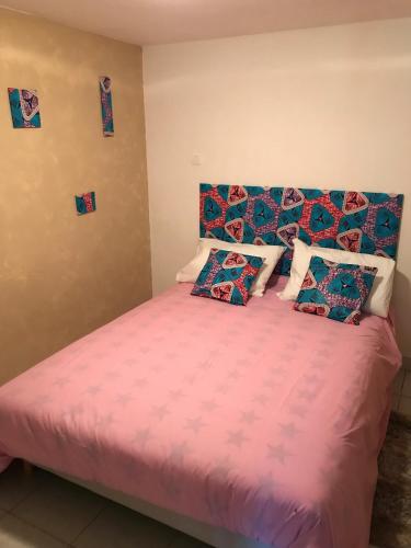 - une chambre avec un lit doté de draps et d'oreillers roses dans l'établissement Un Appart Haut Alpin Chez Les Chtis, à Gap