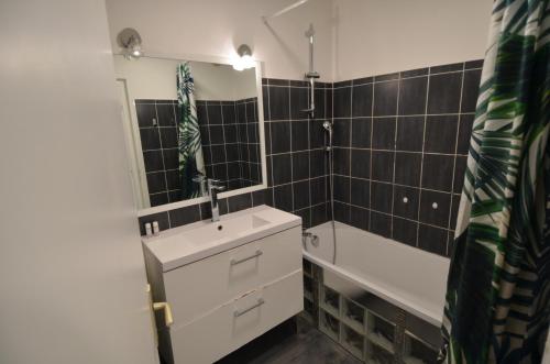 une salle de bain avec un lavabo, une baignoire et un miroir dans l'établissement PLEIN CIEL - Appartement 5 personnes avec piscine sur la Corniche Fleurie à Nice, à Nice