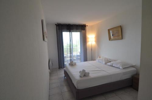 une chambre avec un lit avec des draps blancs et une fenêtre dans l'établissement PLEIN CIEL - Appartement 5 personnes avec piscine sur la Corniche Fleurie à Nice, à Nice