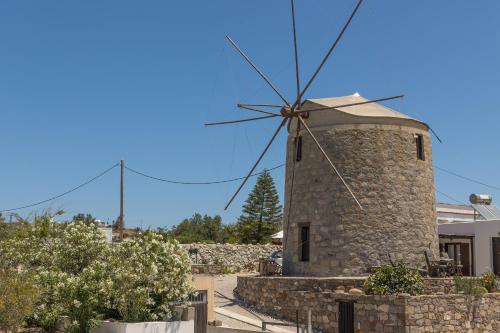 a stone windmill on the side of a house at Ostria Hotel  in Adamas