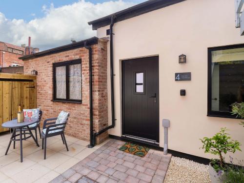 a patio with a black door and a table at The Old Bakehouse in Beverley