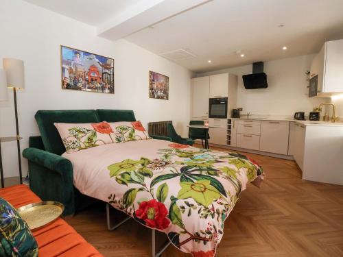 a bedroom with a large bed and a kitchen at The Old Bakehouse in Beverley