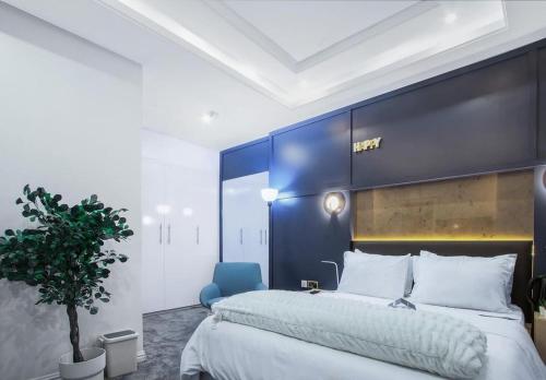 a bedroom with a large bed and a blue wall at Wallgate Apartments Limited in Jahi