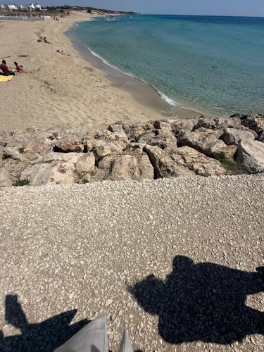 two shadows of people on a rocky beach at Core Salentino Rooms in Campomarino