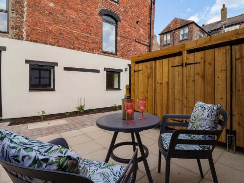 a patio with two chairs and a table with two glasses at The Old Bakehouse in Beverley