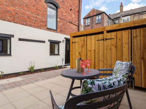 a patio with a table and chairs and a fence at The Old Bakehouse in Beverley