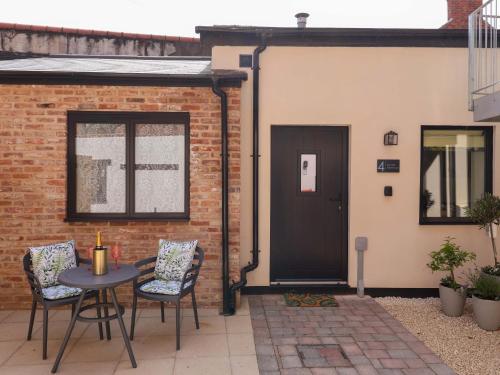a patio with a table and chairs and a door at The Old Bakehouse in Beverley