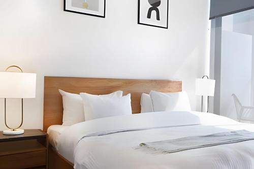 a bedroom with a large white bed with two lamps at Sao Paulo Vertical in Guadalajara