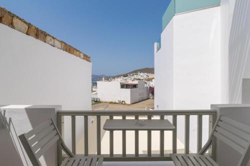 a balcony with two chairs and a table at Ostria Hotel  in Adamas