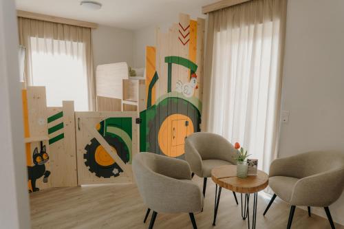 a living room with chairs and a table and a mural at Familienhotel Friedrichshof in Obertrubach