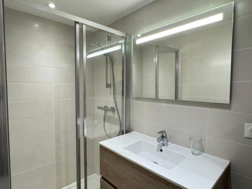 une salle de bain avec un lavabo et une douche avec un miroir dans l'établissement Les Gets - Magnifique apartement dans le centre du village - FR-1-623-184, aux Gets