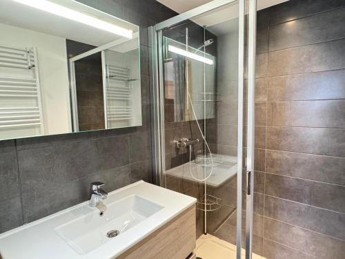 une salle de bain avec un lavabo et une douche dans l'établissement Appartement neuf, luxueux, au cœur des Gets avec terrasse, parking sécurisé, proche commerces et pistes. - FR-1-623-116, aux Gets
