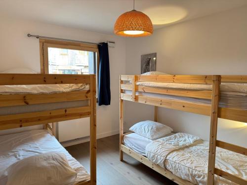 une chambre avec deux lits superposés et une fenêtre dans l'établissement Appartement familial de luxe, centre station, 6 pers., 2 sdb, terrasse, parking, WIFI, linge inclus - FR-1-623-179, aux Gets