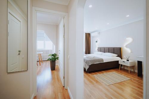a white bedroom with a bed and a hallway at Central 1BR Near Piața Centrală & Bus Station in Chişinău