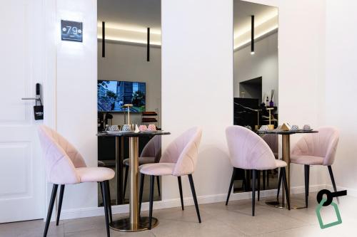 那不勒斯HOTIDAY Room Collection - Napoli Museo Suite的带粉色椅子和镜子的更衣室