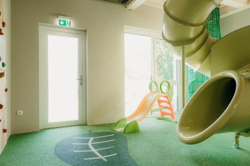 a childs play room with a slide and a slide at Familienhotel Friedrichshof in Obertrubach