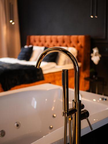 a bathroom with a bath tub with a bed at Merido Apartment in Nitra