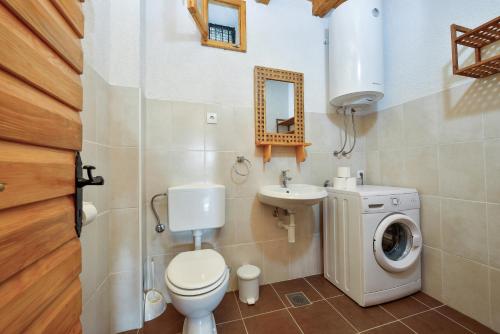 un bagno con un lavandino del water e una lavatrice di Holiday Home Sudinjevi Dvori a Sukošan (San Cassiano)