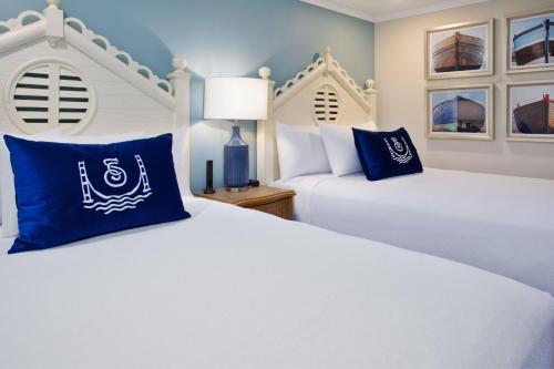 two beds with blue and white pillows in a room at The Inn at Stonecliffe in Mackinac Island