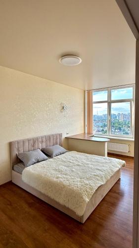 a bedroom with a large bed in front of a window at Апартаменти з видом на море та місто in Odesa