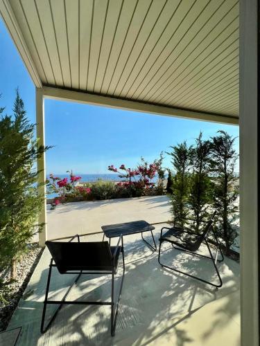 a table and chairs on a patio with a view of the ocean at Green Condo Hotel Palase in Palasë