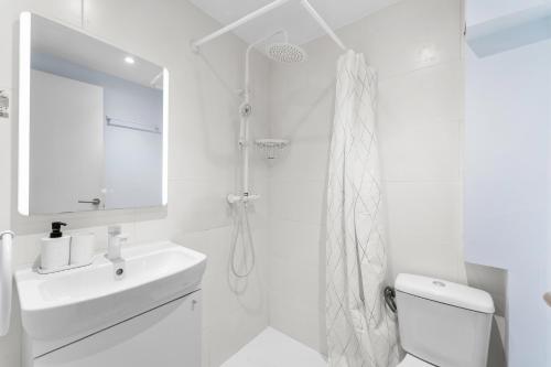a white bathroom with a sink and a shower at Amena Mar Hotel in Sa Coma
