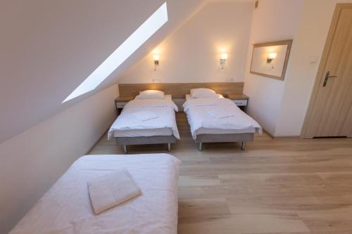 a row of beds in a room with a attic at Kresovia in Giby