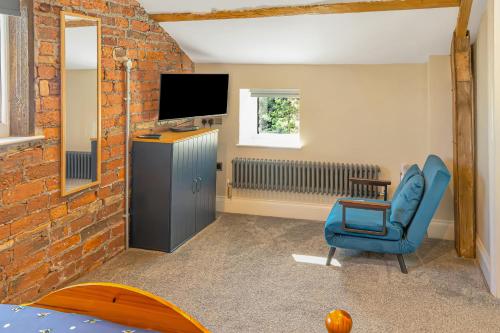 a living room with a blue chair and a television at Luxury Escape with Cinema, Pool Table & Darts in Leeds