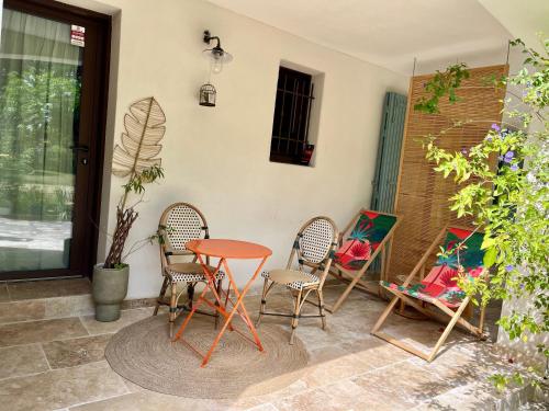 a patio with a table and chairs on a patio at Beau studio dans mas provençal in Avignon
