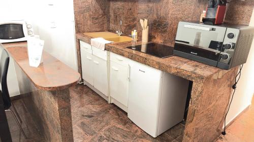 una cucina con un piano di lavoro con un forno a microonde di Appartement 4 personnes Drancy a Drancy