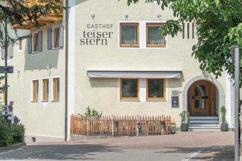 a building with a fence in front of it at Gasthof Teiser Stern in Funes