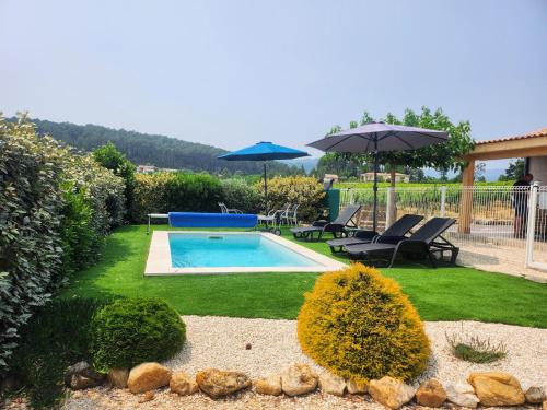 - une piscine dans une cour avec 2 parasols dans l'établissement En Ardèche, gîte L'Odalys climatisé avec sa piscine privée et chauffée, à Joyeuse