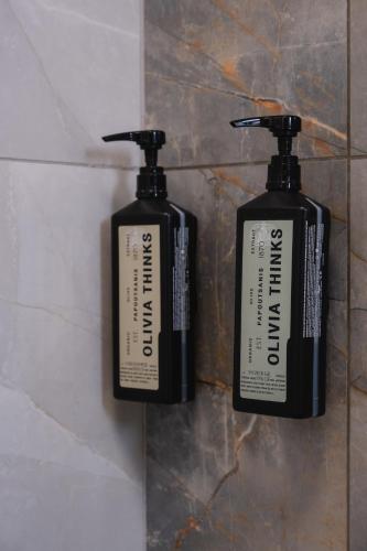 two black and white soap bottles on a wall at Filia Skyros Suites in Skiros