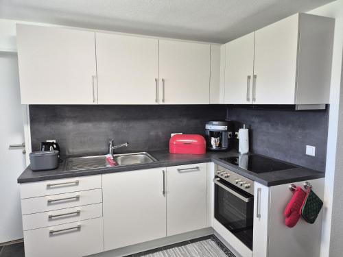 a kitchen with white cabinets and a sink at Ferienwohnung Ankerplatz in Schluchsee