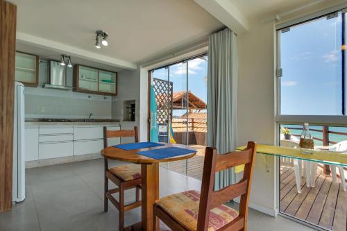 a kitchen and dining room with a table and chairs at Residencial Vila do Sol, Apartamentos com pé na areia in Bombinhas