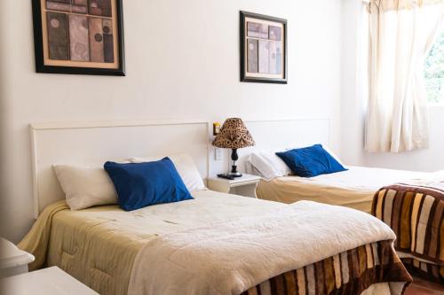 two beds in a room with blue pillows at SOLACHE INN in Zitácuaro