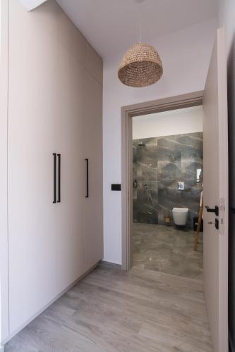 a hallway with a bathroom with a toilet and a door at Filia Skyros Suites in Skiros