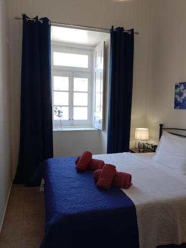 a bedroom with a bed with two red pillows on it at Blue Sky - Hydra Memories House in Hydra
