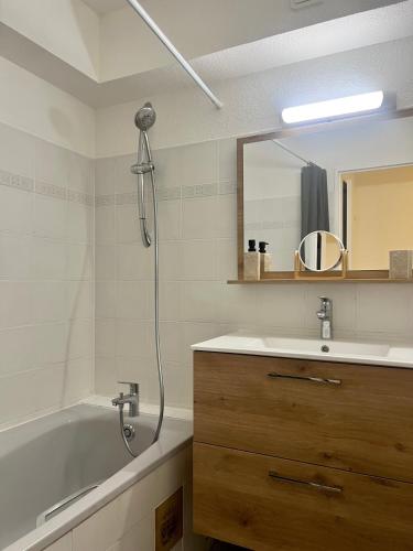 une salle de bain avec une baignoire, un lavabo et un miroir dans l'établissement Chez Francesco, artist's apartment, à Montpellier