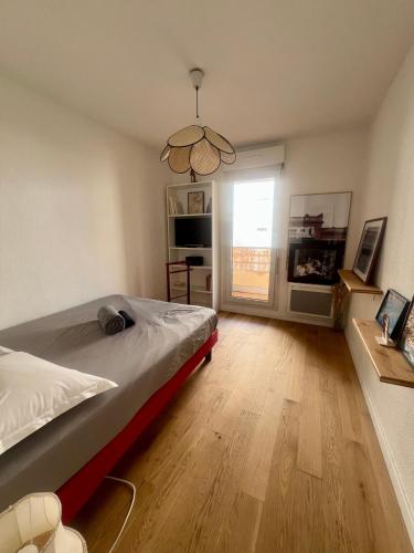 une chambre avec un lit et une grande fenêtre dans l'établissement Chez Francesco, artist's apartment, à Montpellier