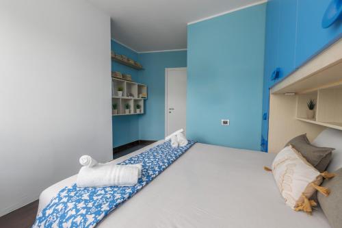 a bedroom with a large white bed with blue walls at Lake & Whispers - Among Lake Como and Switzerland in San Fedele Intelvi