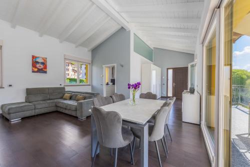 a dining room with a table and chairs and a couch at Lake & Whispers - Among Lake Como and Switzerland in San Fedele Intelvi