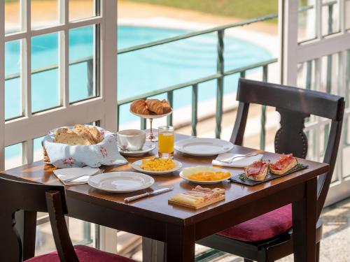 a table with breakfast food on a balcony at Forrester Essence Douro Hotel - by Unlock Hotels in Alijó