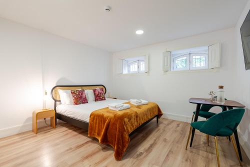a bedroom with a bed and a table and a chair at Casa D'Almeida by Porto Stories in Porto