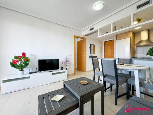 a living room with a dining table and a kitchen at Loft Costero in Oropesa del Mar